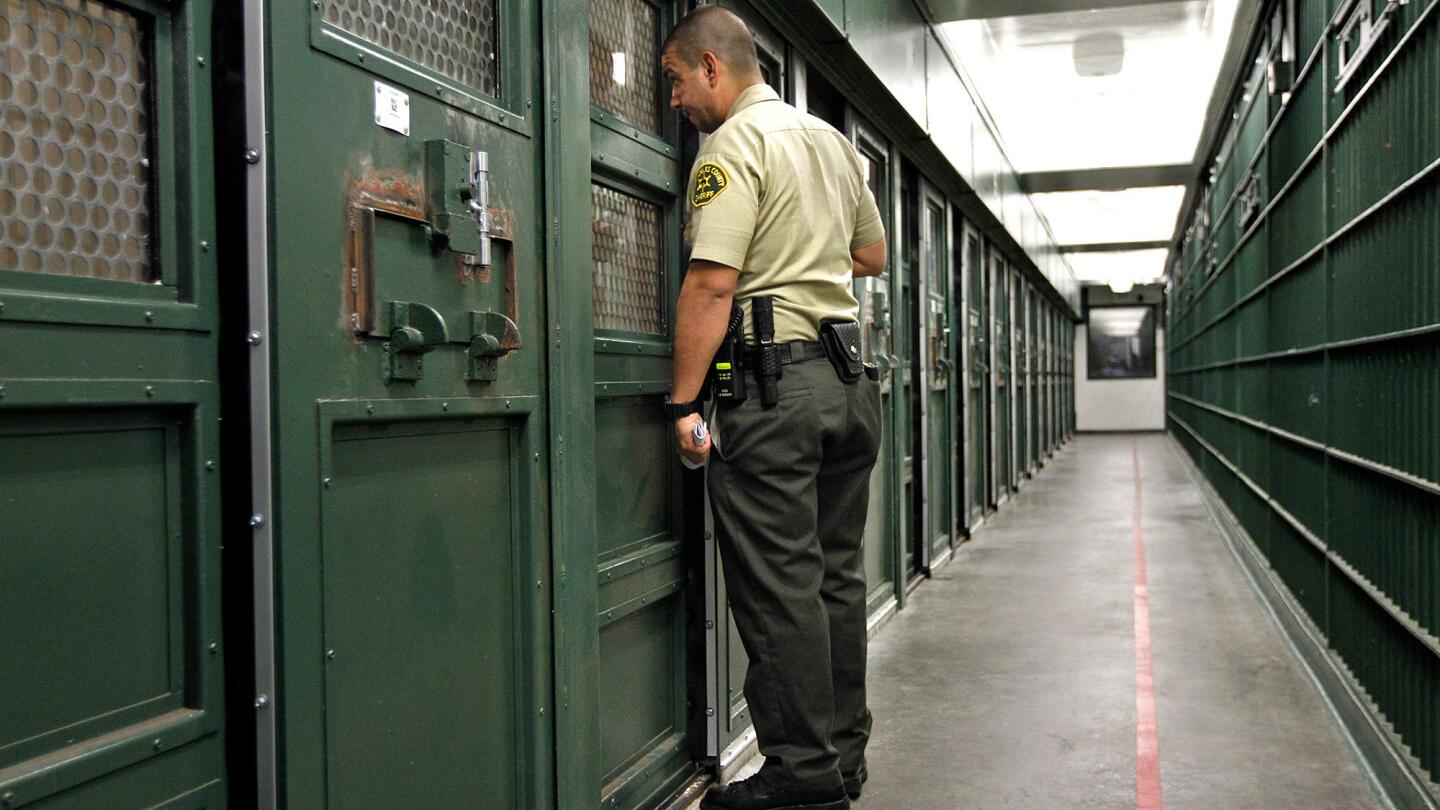 Sheriff's Deputy Miguel Vega checks on an inmate in "gassers alley" at the Men's Central Jail.