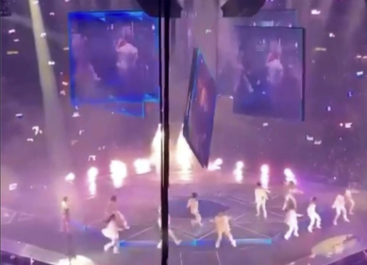 CORRECTS DATE - In this image made from video taken from social media, a massive video screen suspended above the stage fells onto performers at a concert of Cantopop boy band Mirror, in Hong Kong, Thursday, July 28, 2022. Two dancers were injured at a Cantopop concert in Hong Kong after a massive video screen suspended above the stage fell onto performers below. (AP Photo)