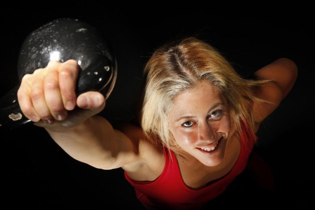 Fitness trainer Lacey Stone lifts a kettle bell.