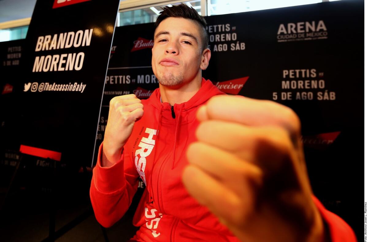 Tijuana-bred flyweight champion Brandon Moreno holds his fists up in a fight pose while pausing on a red carpet