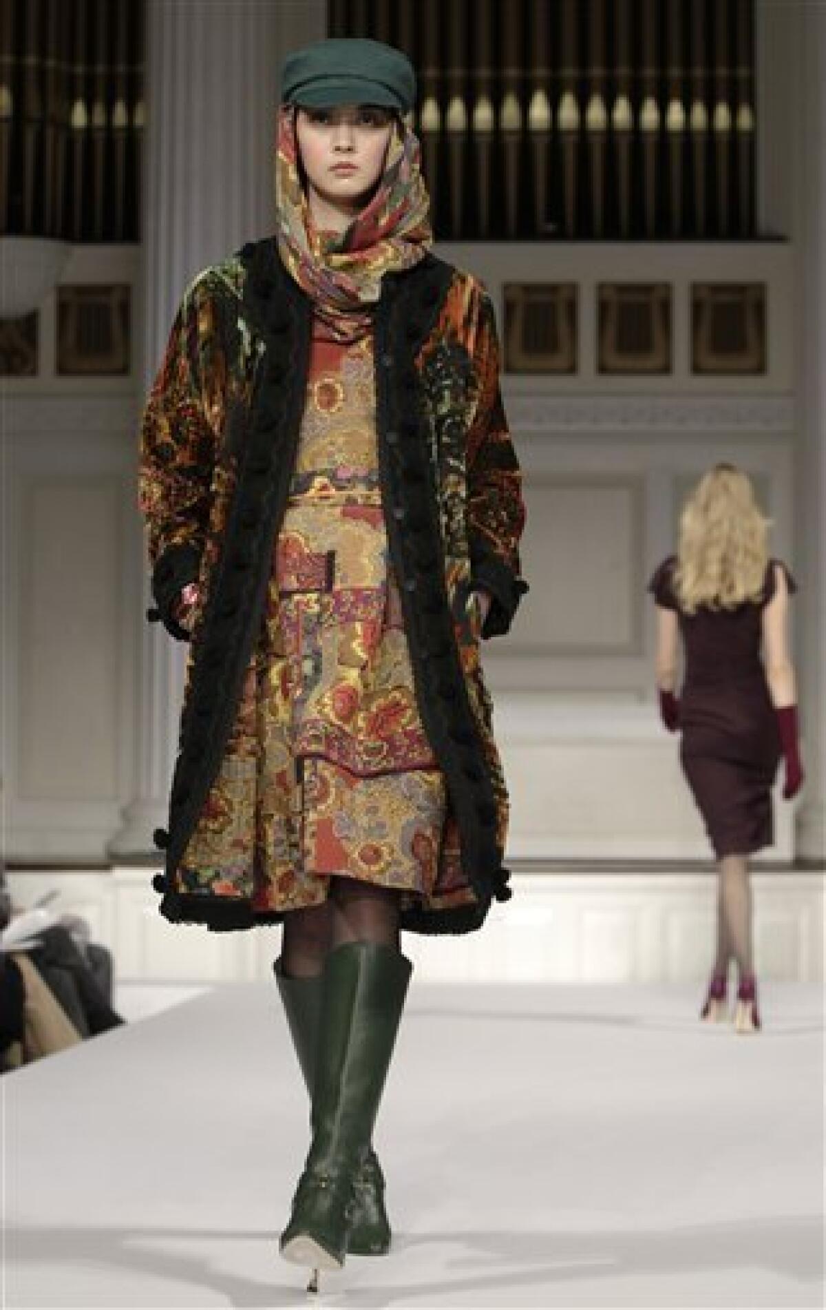 A model opens Oscar de la Renta's Fall 2011 show wearing a colorful embroidered coat during Fashion Week in New York, Wednesday, Feb. 16, 2011. (AP Photo/Kathy Willens)