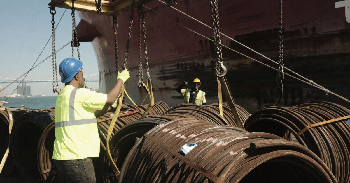 Photo: latimes.com Workers unload bar-in-coil steel from a freight ship in the dockyard at the Port of Detroit in Detroit, Michigan