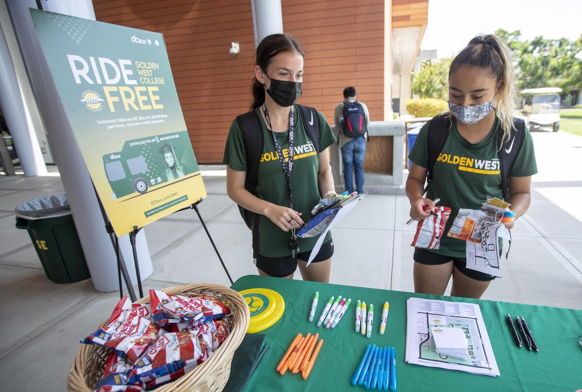 Kennedy Klumker, left, and Elizabeth Reyes help themselves to some goodies in front of the Student Services Center on Monday.