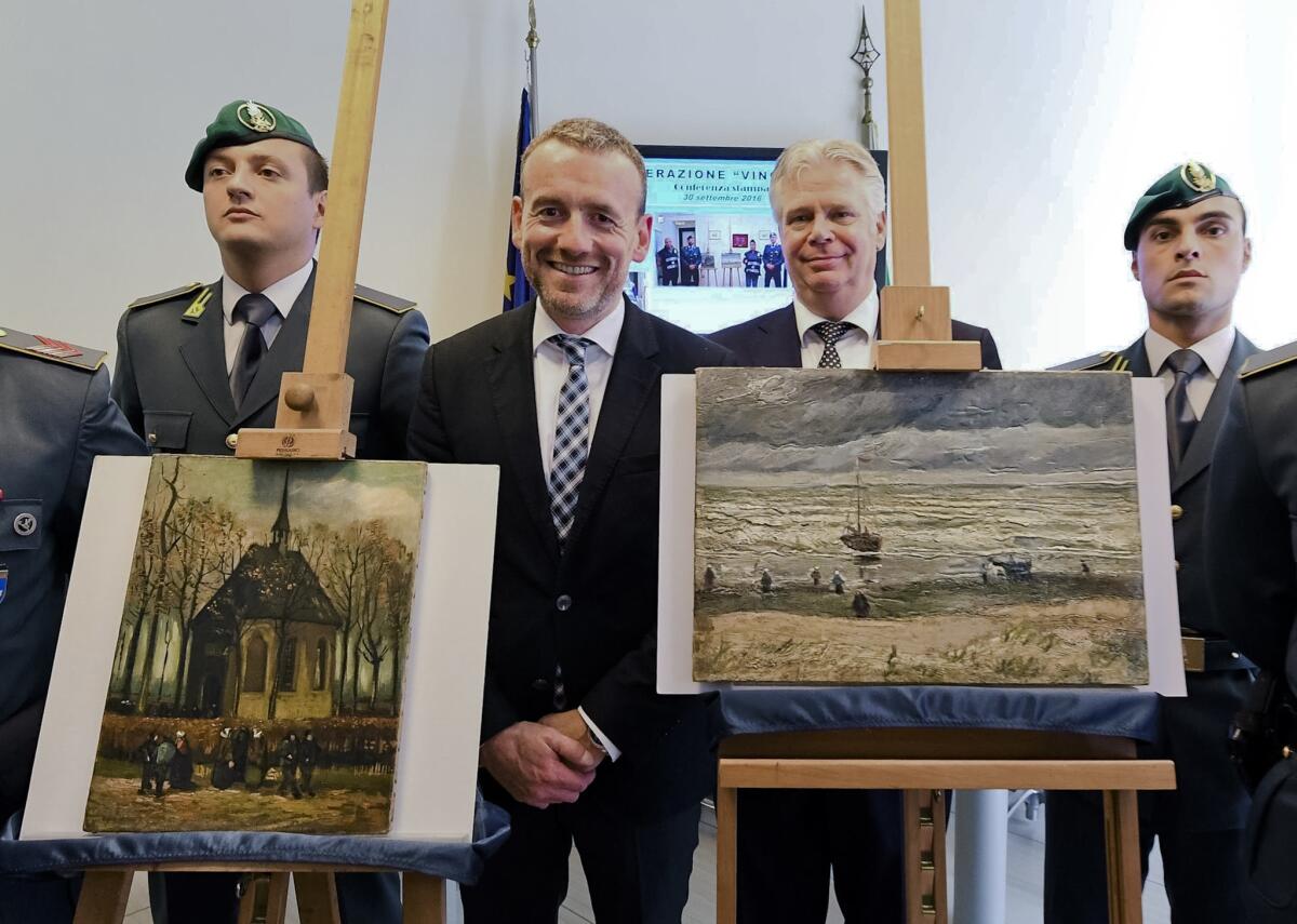 Alex Rueger, center, director of Amsterdam's Van Gogh Museum, stands next to the paintings "Congregation Leaving the Reformed Church in Nuenen," left, and "Seascape at Scheveningen" by Vincent van Gogh on Friday.