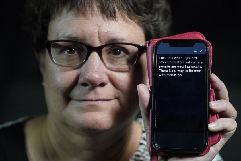 Chelle Wyatt uses her cell phone with the Otter app Friday, April 15, 2022, in Salt Lake City. People with hearing loss have adopted technology to navigate the world, especially as hearing aids are expensive and inaccessible to many. (AP Photo/Rick Bowmer)