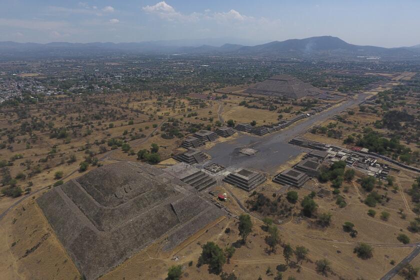 FILE - In this March 19, 2020 file photo, the Pyramid of the Moon, left, and the Pyramid of the Sun, back right, are seen along with smaller structures lining the Avenue of the Dead, in Teotihuacan, Mexico. The Mexican government said Tuesday, May 25, 2021, that a private building project is destroying part of the outskirts of the pre-Hispanic ruin site of Teotihuacan, just north of Mexico City. (AP Photo/Rebecca Blackwell, File)