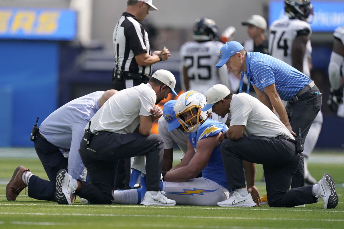 Los Angeles Chargers linebacker Joey Bosa, middle, is checked on by trainers during the first half of an NFL football game against the Jacksonville Jaguars in Inglewood, Calif., Sunday, Sept. 25, 2022. (AP Photo/Mark J. Terrill)