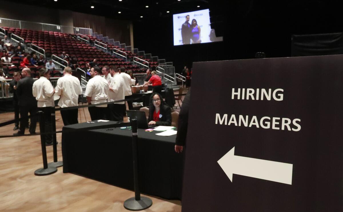 Managers wait for job applicants at a job fair in Hollywood, Fla., in June. Unemployment is at a 50-year low, but fewer employers are raising pay, a survey found.