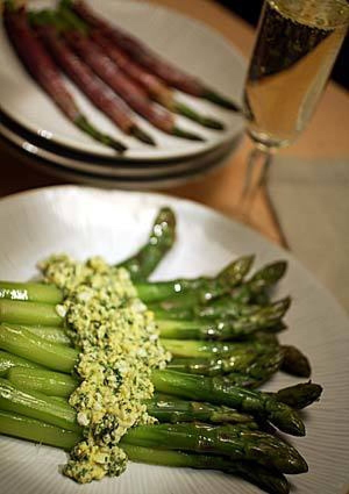 LUSCIOUS: Thick asparagus are served with sauce mimosa, a vinaigrette enriched with hard-boiled eggs. In the background, medium spears are wrapped in prosciutto and roasted.