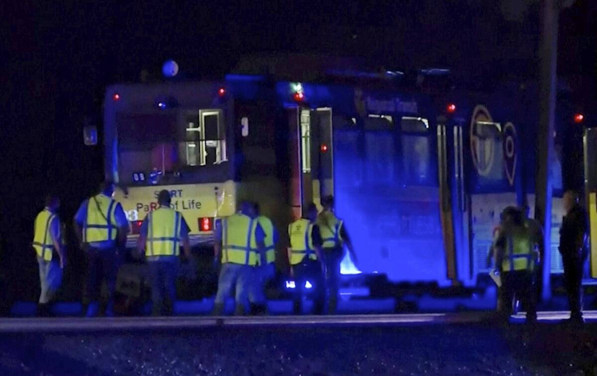 In this image from video, emergency workers gather around a light rail train Thursday in Sacramento that crashed into another train, injuring more than two dozen people.