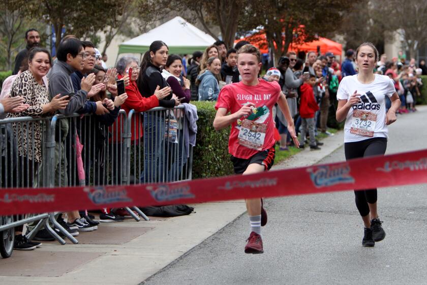 Graysen Schick, 12 of Rancho Santa Margarita, left, won the boys 1K while sienna Stand, 12 of Aliso Viejo, right, won the girls 1K of the 6th Annual Run for a Claus 5k and 1-Mile Kids Run/Walk, at University of California, Irvine on Saturday, Dec. 7, 2019.