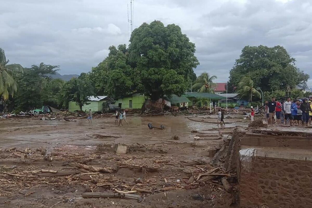 Residents survey damage at a village in eastern Indonesia after a flash flood.