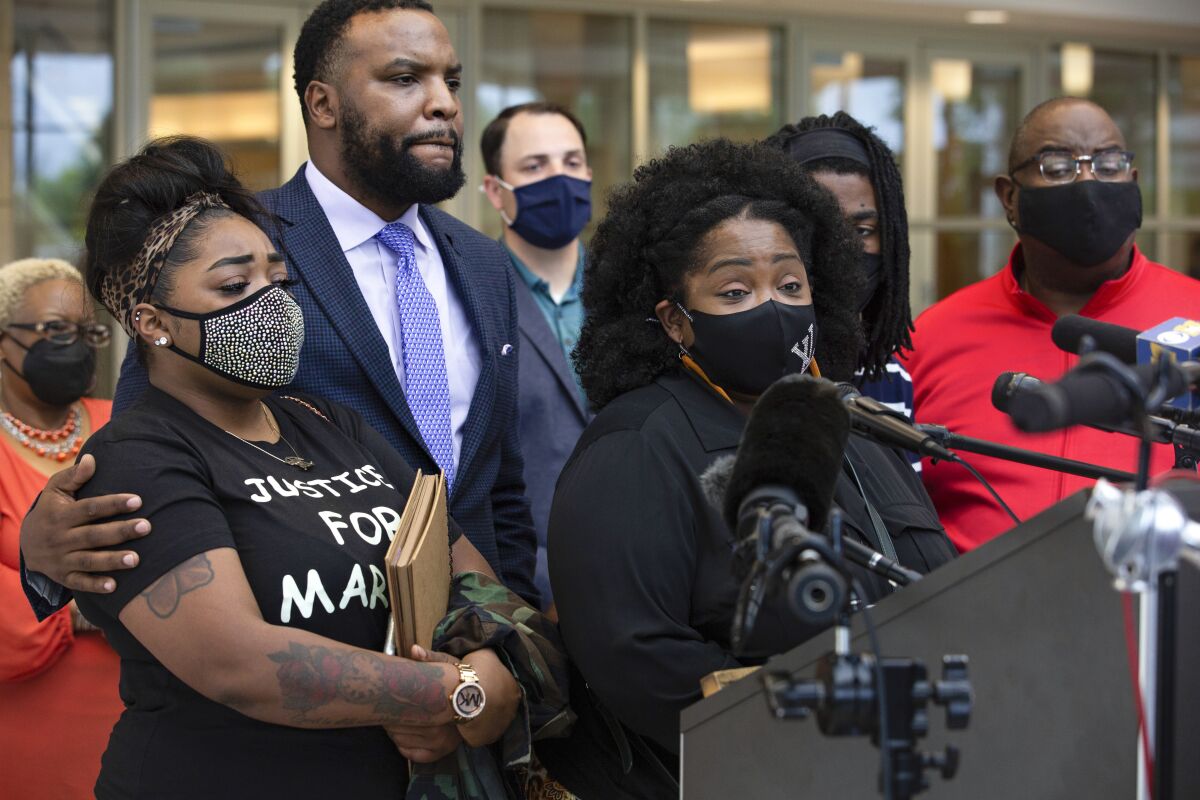 FILE - LaSandra Scott, center right, speaks during a news conference concerning updates on her son Marvin Scott III's in-custody death at the Collin County Courthouse as attorney Lee Merritt, center left, listens in McKinney, Texas, on April 28, 2021. Prominent civil rights attorney Merritt was among a group of people arrested in a Dallas suburb during a demonstration in memory of Marvin Scott III, a Black man who died in a struggle with guards at an area jail. (Shelby Tauber/The Dallas Morning News via AP, File)