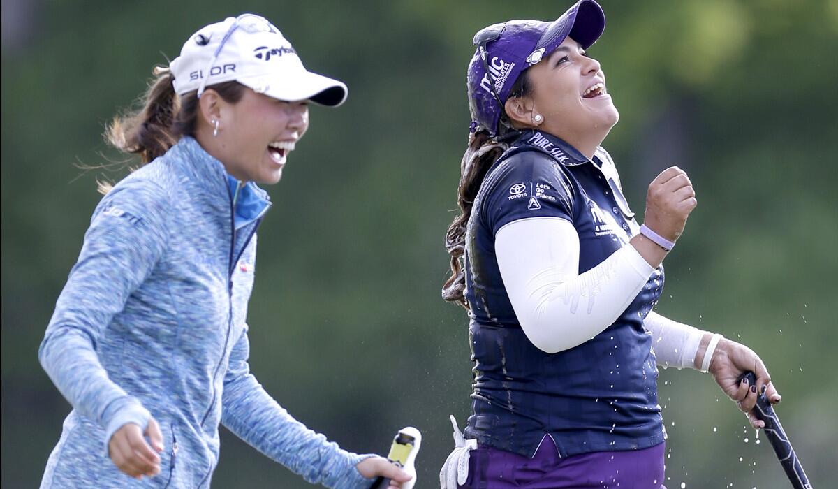 Lizette Salas, right, is all smiles after getting drenched by fellow golfer Nina Harigae while celebrating a victory at the Kingsmill Championship on Sunday.