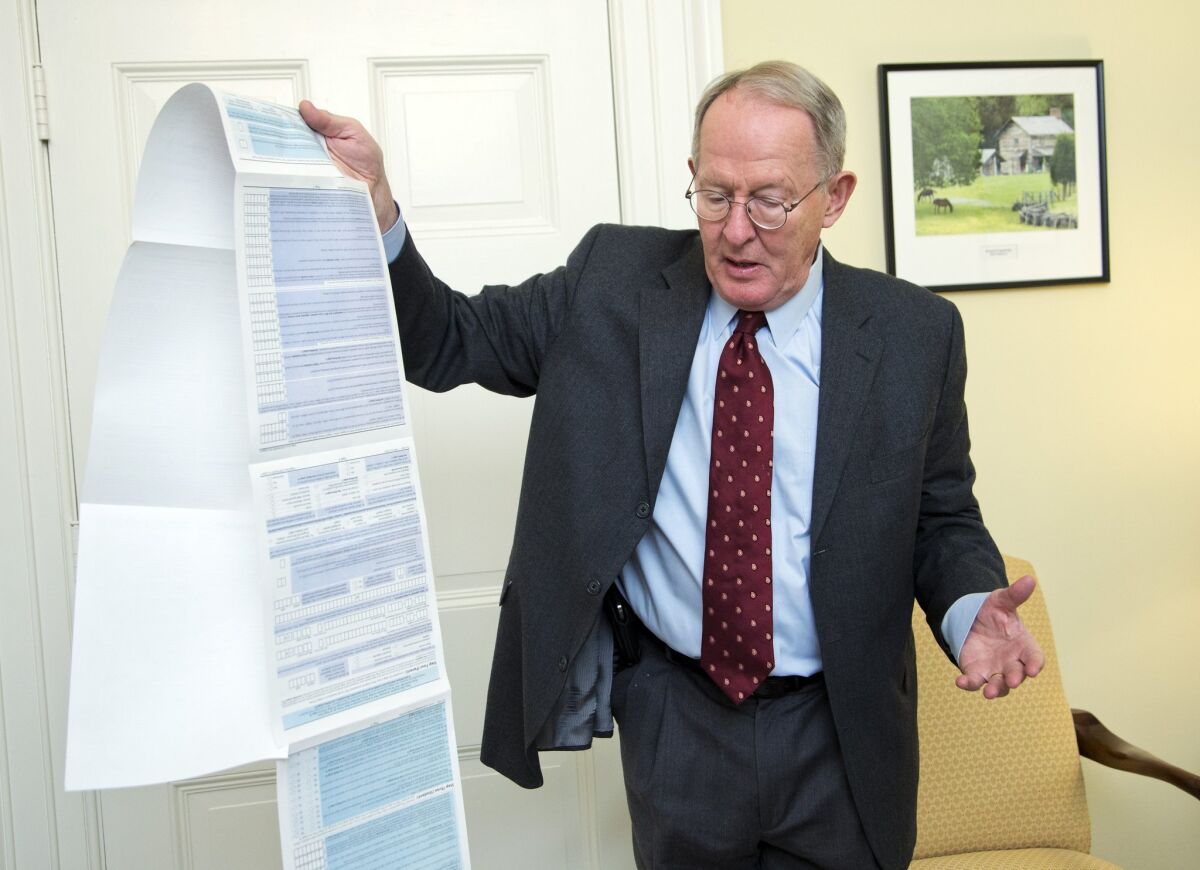 Sen. Lamar Alexander, R-Tenn., shows the Free Application for Federal Student Aid (FAFSA) form during an interview on Capitol Hill in Washington on Nov. 14.