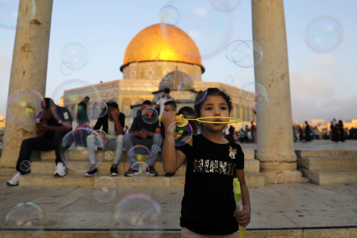 Jerusalem: A young Palestinian girl blows soap bubbles near the Dome of the Rock at Al-Aqsa Mosque compound in Jerusalem's old city on the first day of Eid al-Adha.