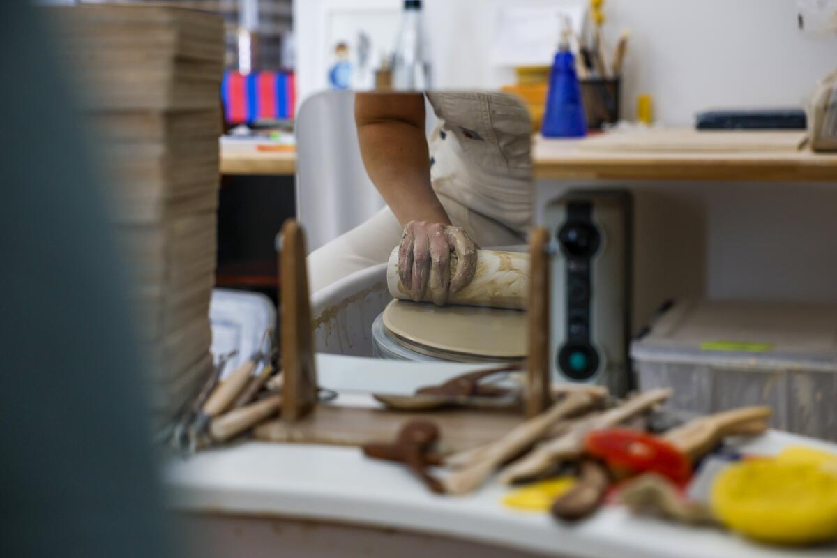Becki Chernoff crafts a plate on her potter's wheel
