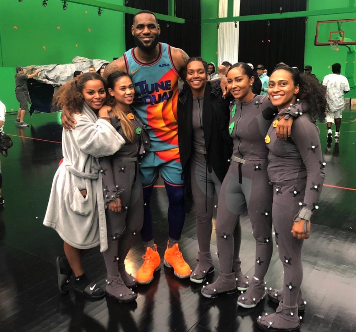 Darxia Morris (black sweater) and Mariah Williams (far right) pose for a photo with LeBron James and Tune Squad members.