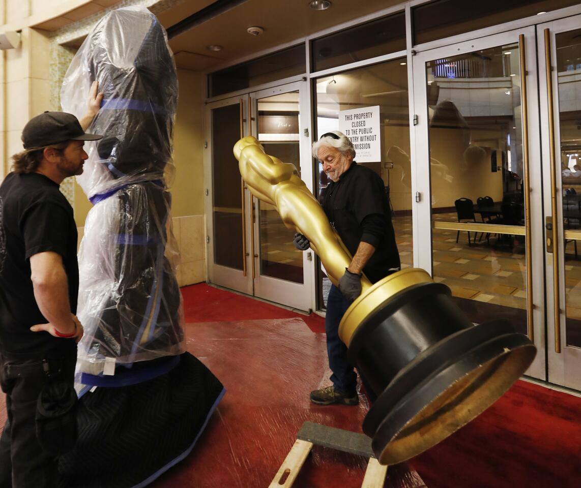 Worker Frank Rose lifts an Oscar statue into the Dolby Theatre during rehearsals for the 91st Oscars show Sunday.