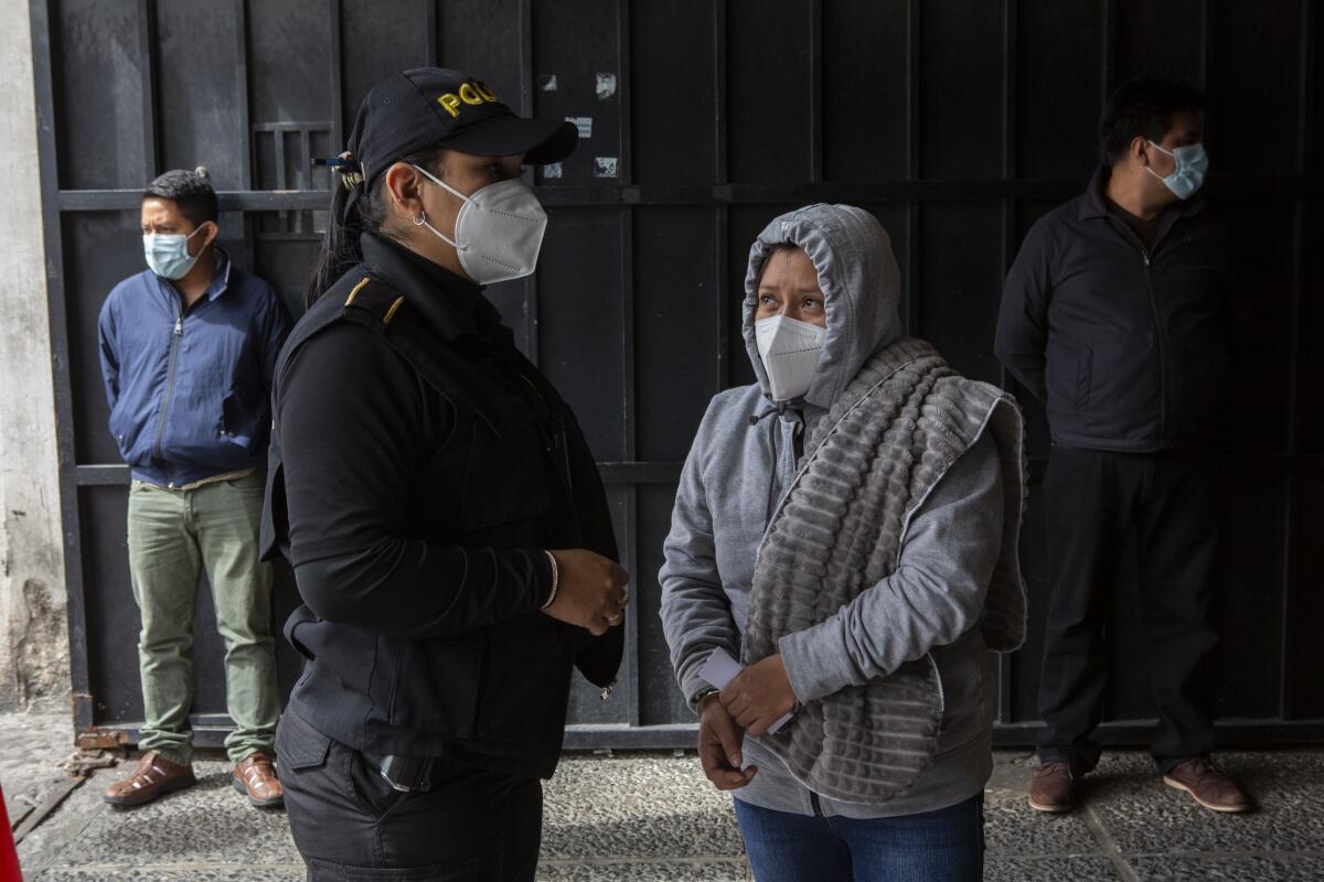 La detenida Ana Mateo Baltasar aparece esposada junto a un oficial de policía 