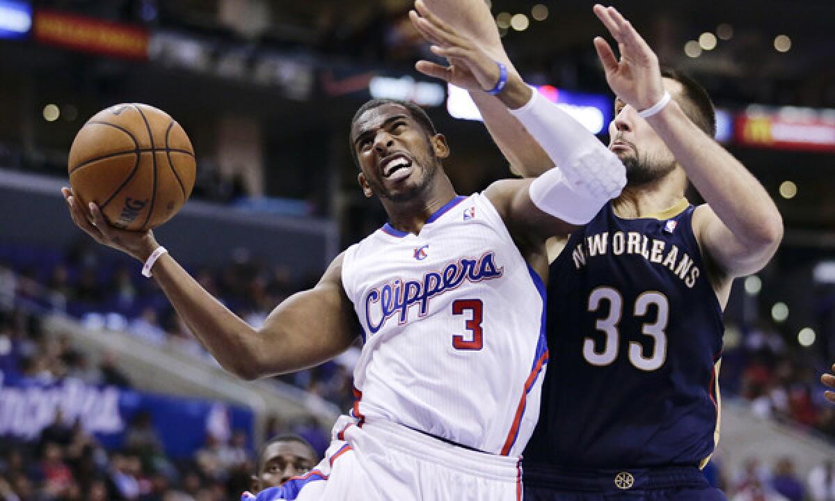 Clippers point guard Chris Paul, left, goes up for a basket in front of New Orleans Pelicans power forward Ryan Anderson during the Clippers' 108-95 win Dec. 18. Paul will return from injury against the Philadelphia 76ers on Sunday.