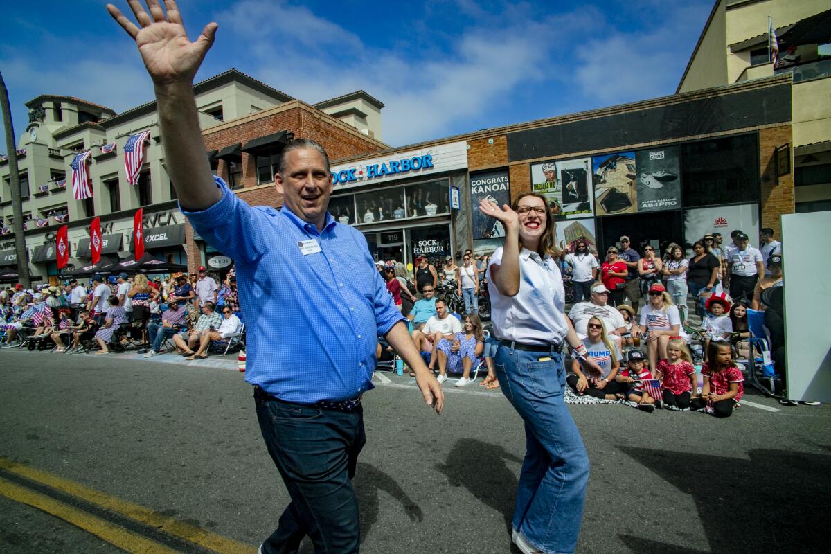 Huntington Beach Mayor Tony Strickland and daughter Ruby wave to the crowd during Tuesday's Fourth of July parade.