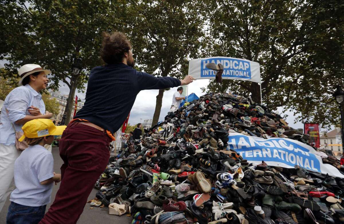 A man adds to a pile of shoes in Paris during a demonstration against land mines Sept. 20. The U.S. has pledged to get rid of its stockpiles of land mines except those on the Korean peninsula.
