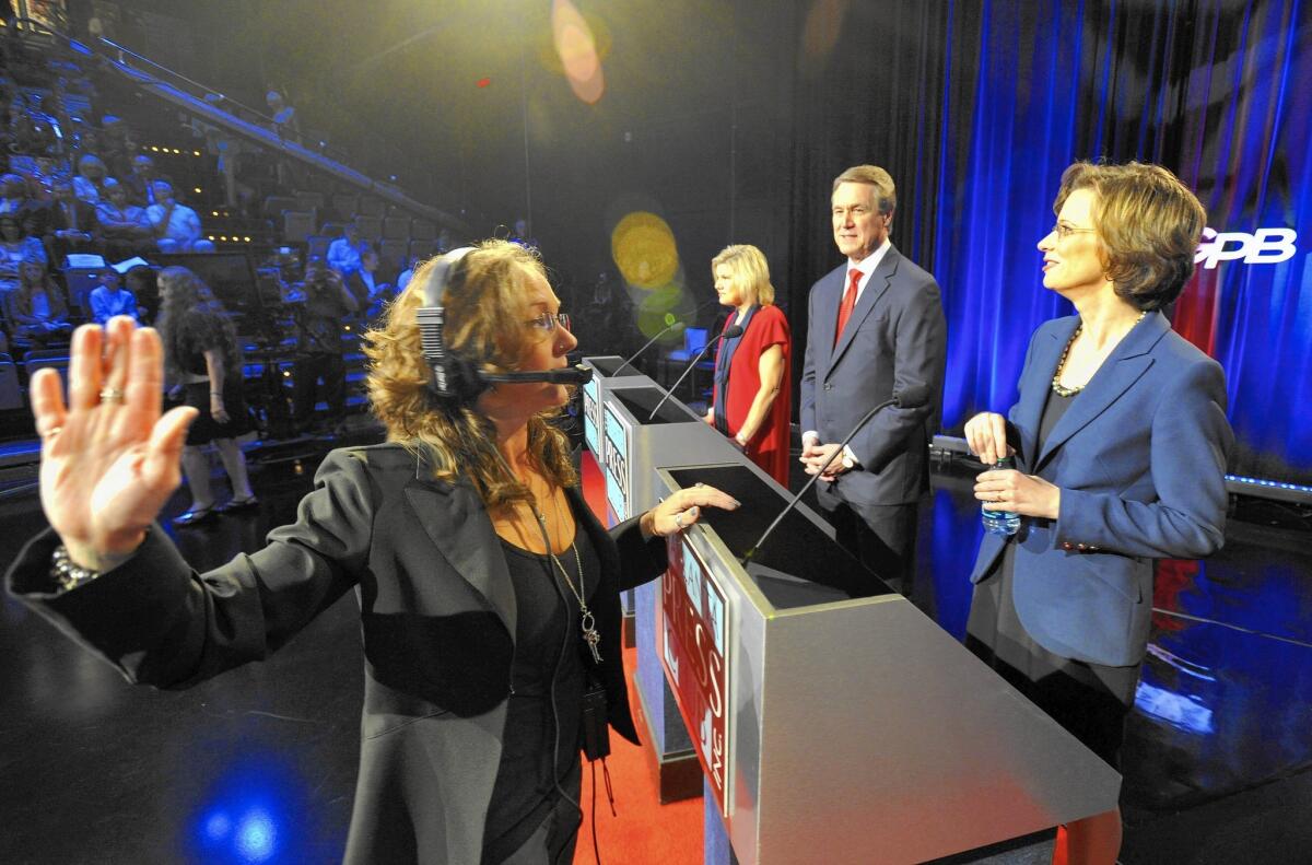 Georgia Public Broadcasting director Shannon Phillips advises U.S. senatorial candidates, including Democrat Michelle Nunn, right, and Republican David Perdue, before their debate Oct. 26 in Atlanta.