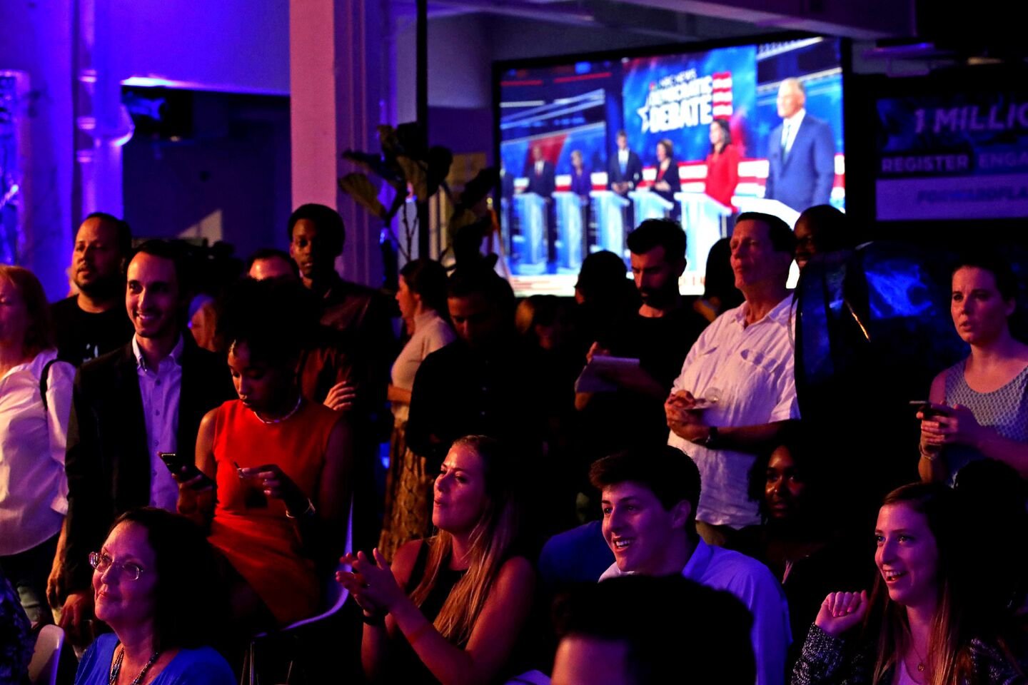 People react at a watch party for the first Democratic presidential primary debates for the 2020 elections in Miami on Wednesday, June 26, 2019.