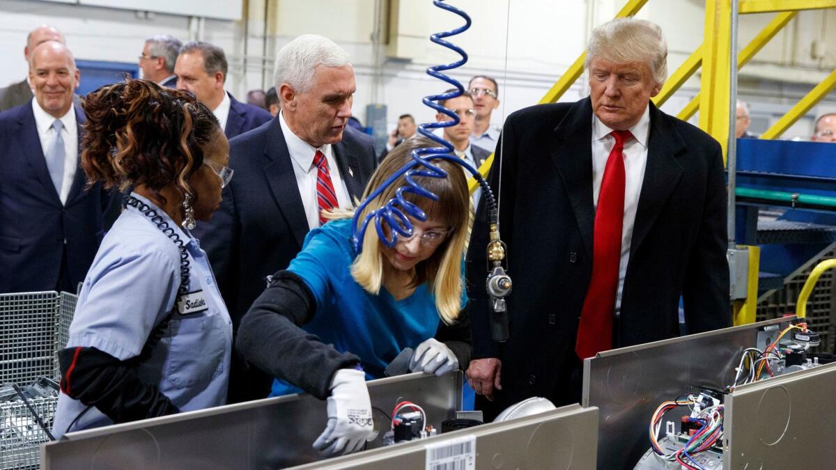 Then-president-elect Trump and Vice President-elect Mike Pence watch employees work at a Carrier factory in Indianapolis on Dec. 1.