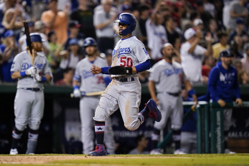 Los Angeles Dodgers' Mookie Betts scores on a single by Max Muncy during the seventh inning of a baseball game against the Washington Nationals, Friday, July 2, 2021, in Washington. (AP Photo/Julio Cortez)
