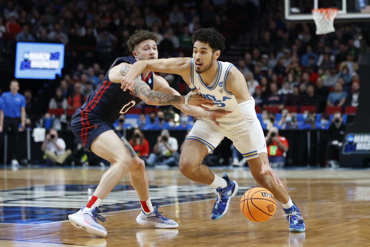 UCLA guard Johnny Juzang drives around St. Mary's guard Logan Johnson.