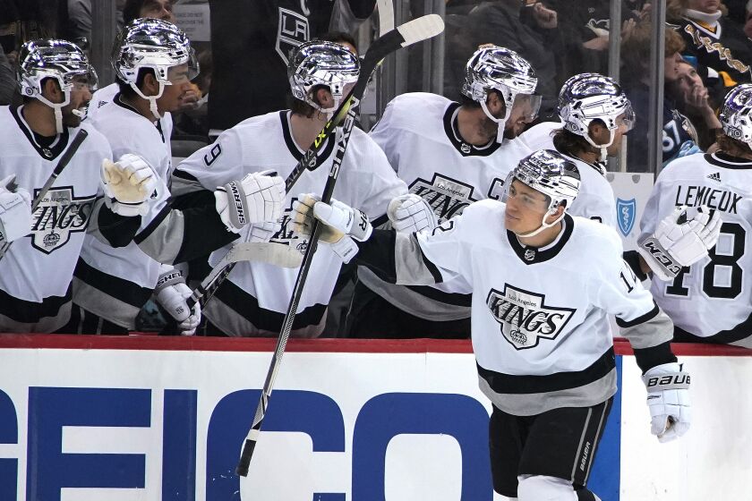 Los Angeles Kings' Trevor Moore (12) returns to the bench after scoring during the second period.