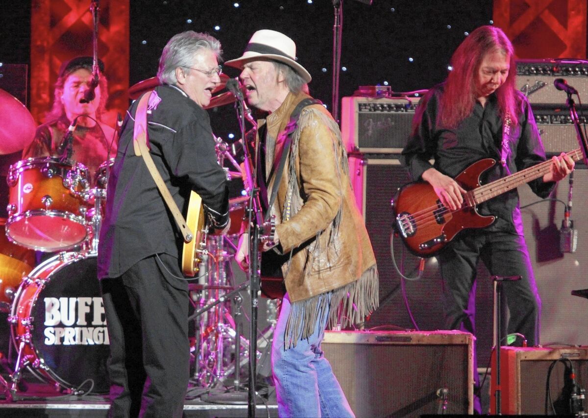 Longtime session musician Rick Rosas, right, here playing with Neil Young, center, Richie Furay and Joe Vitale during a Buffalo Springfield reunion concert in Los Angeles in 2011, has died at the age of 65.