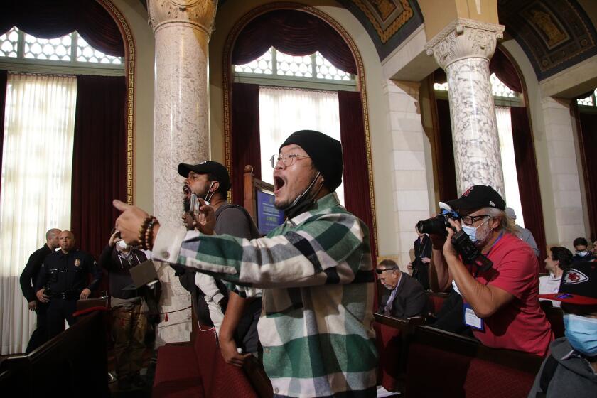 LOS ANGELES CA DECEMBER 9, 2022 - Protestors get vocal inside the Los Angeles City Council chambers after Kevin de Leon showed up at the council meeting Friday morning, Dec. 9, 2022, during public comment. (Myung J. Chun / Los Angeles Times)