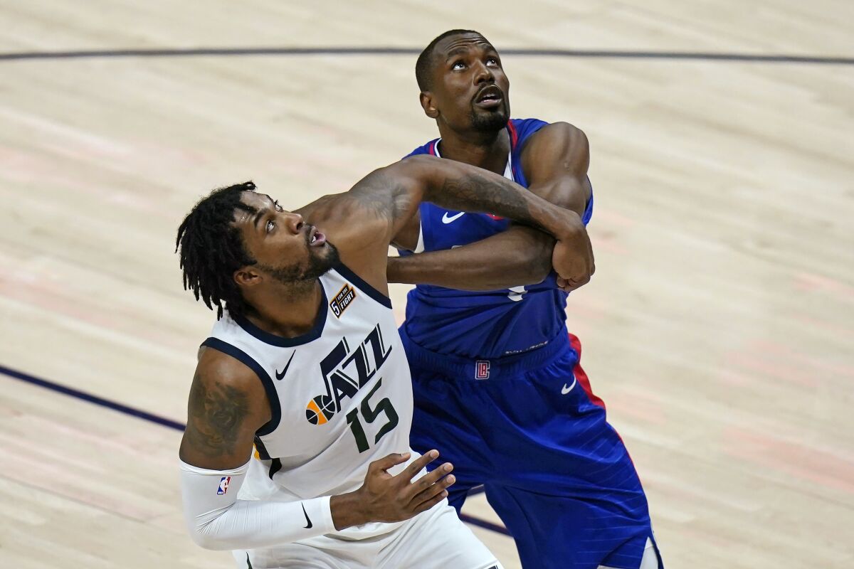 The Clippers' Serge Ibaka, right, battles the Utah Jazz's Derrick Favors for a rebound Jan. 1 in Salt Lake City.