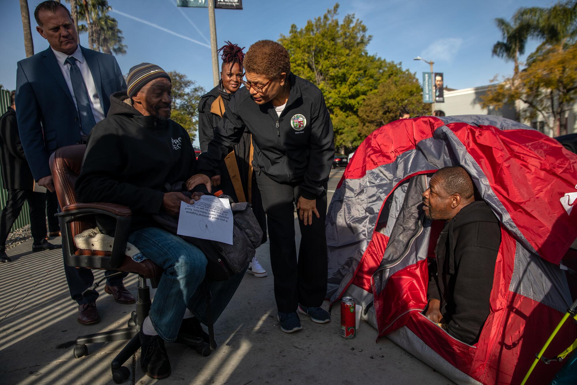 Mayor Karen Bass chats with homeless people living in tents outdoors.
