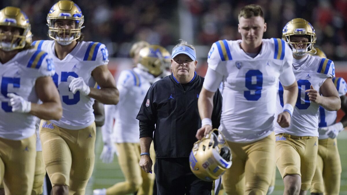 UCLA coach Chip Kelly runs off the field with the team at the end of the first half against UCLA during an NCAA college football game Saturday, Oct. 30, 2021, in Salt Lake City. (AP Photo/Rick Bowmer)