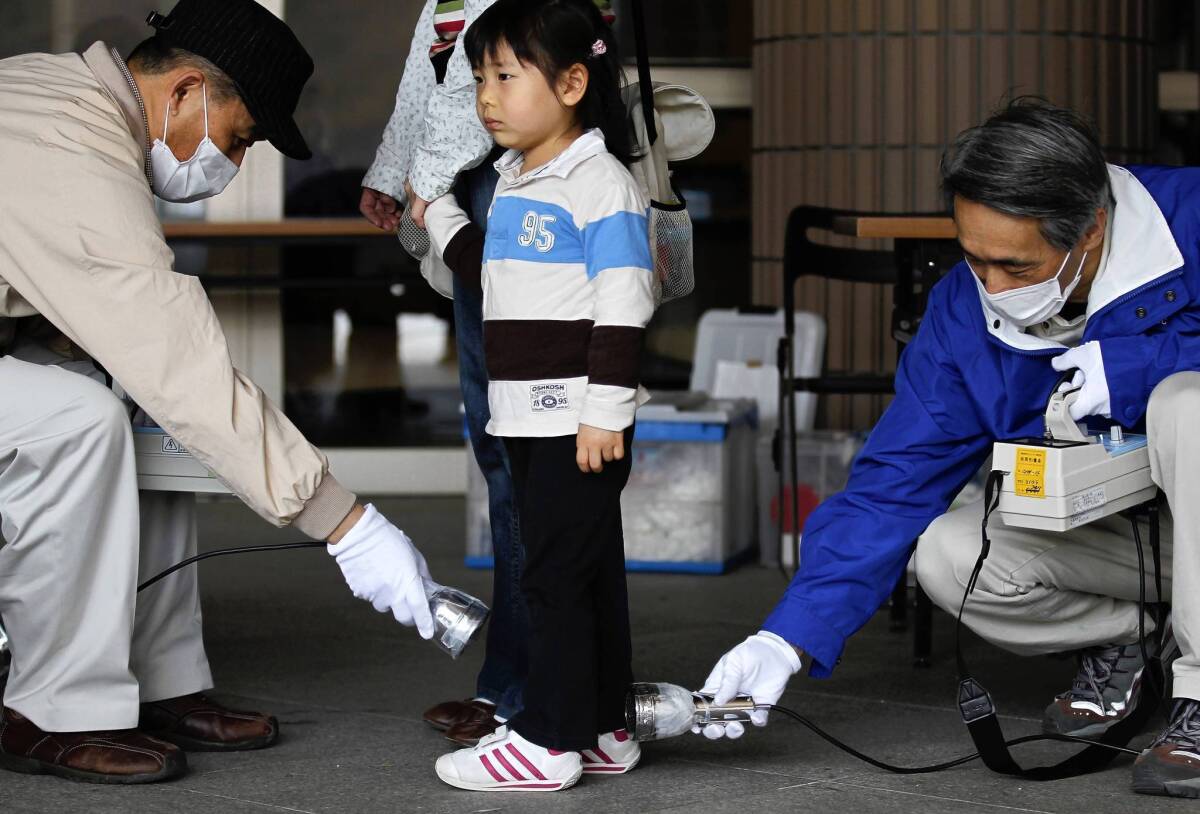 Three-year-old Wakana Nemoto is screened for radiation exposure in Fukushima, Japan, in April 2011, a month after the nuclear plant disaster. Infants who lived in the vicinity at the time face the greatest additional cancer risk during their lifetimes, a World Health Organization report said.