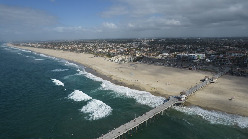 FILE - This aerial photo shows the pier and shoreline in Huntington Beach, Calif., on Oct. 11, 2021. A coyote attacked and injured a girl on Southern California's famed Huntington Beach. A police spokesperson says the attack occurred Thursday, April 28, 2022, at night on the beach on the north side of Huntington Beach Pier. (AP Photo/Ringo H.W. Chiu, File)
