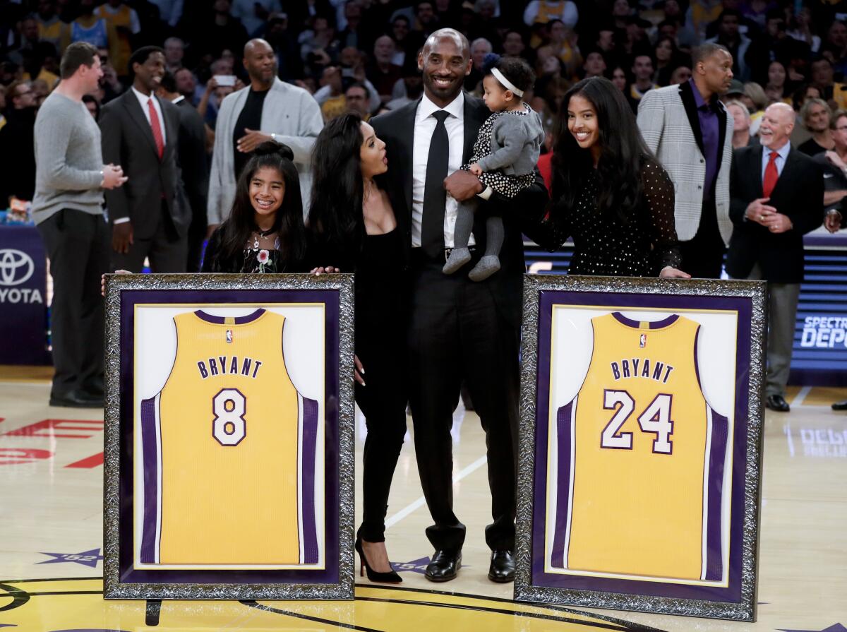 Kobe Bryant poses with his family after getting his jerseys retired Dec. 18, 2017, at Staples Center.