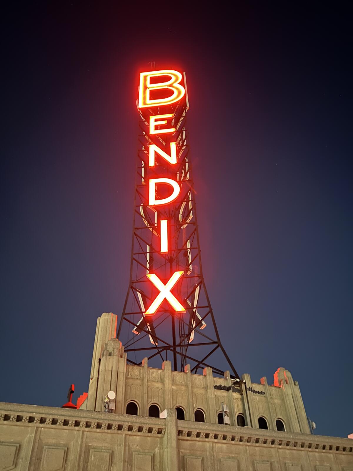 A neon sign at the top of a building