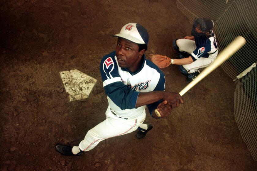 Atlanta Braves outfielder Hank Aaron swings a bat at home plate during spring training in 1974.