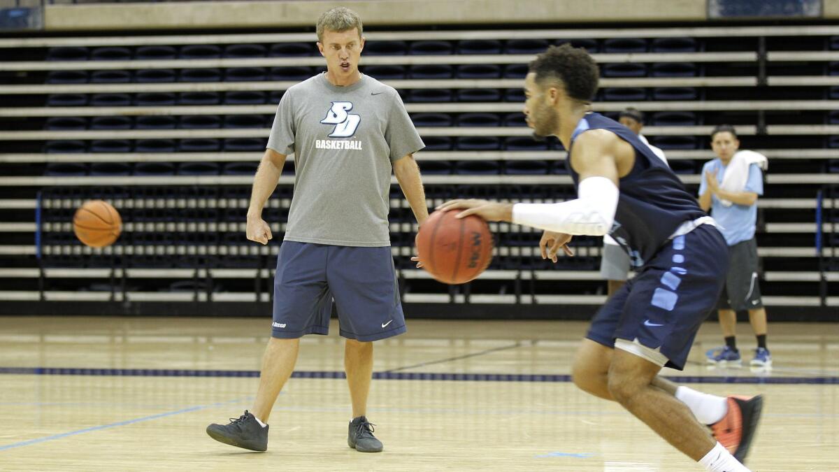USD men's basketball coach Sam Scholl (left) runs the Toreros through a practice. USD is 2-0 and will face the University of Washington Monday night. The Huskies were a team watched as a youth.
