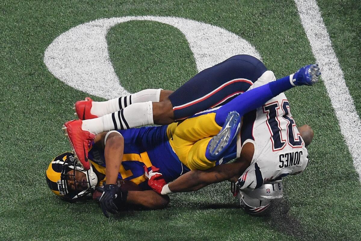 Wide receiver for the Los Angeles Rams Robert Woods (L) is tackled by Jonathan Jones of the New England Patriots during Super Bowl LIII between the New England Patriots and the Los Angeles Rams at Mercedes-Benz Stadium in Atlanta, Georgia, on February 3, 2019.