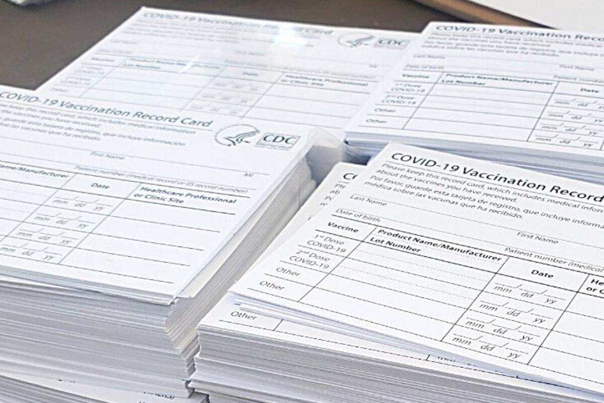 Four stacks of blank COVID-19 vaccination cards