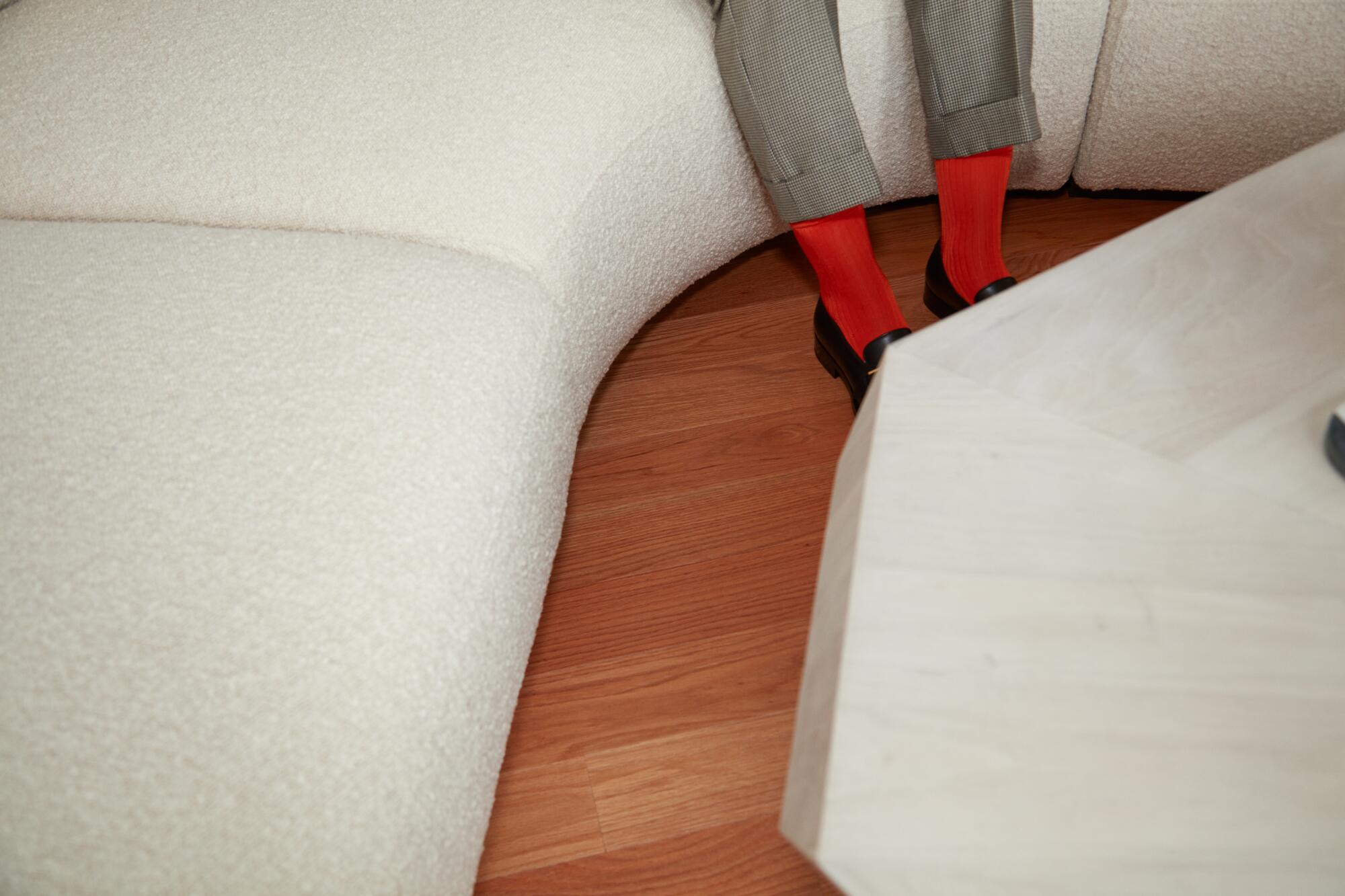 A detail shot of a woman's legs in pants and orange socks.