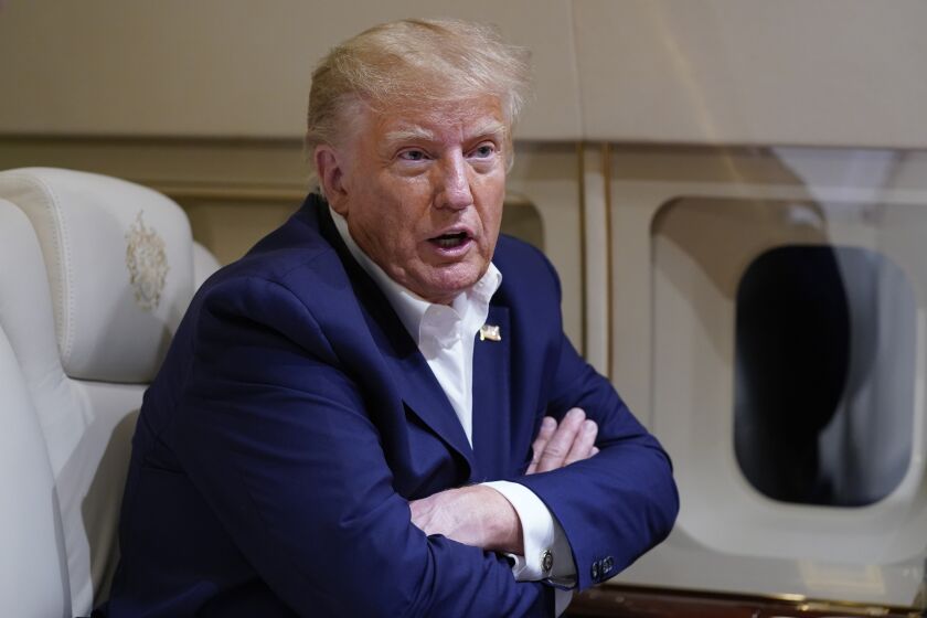 Former President Donald Trump speaks with reporters while in flight on his plane after a campaign rally at Waco Regional Airport, in Waco, Texas, Saturday, March 25, 2023, while en route to West Palm Beach, Fla. (AP Photo/Evan Vucci)