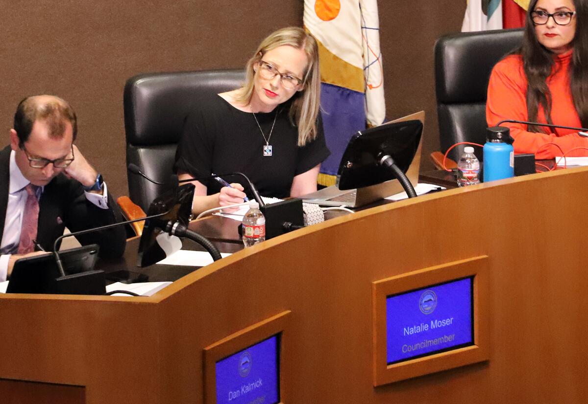 Huntington Beach City Councilwoman Natalie Moser, center, listens to public comments on Tuesday.