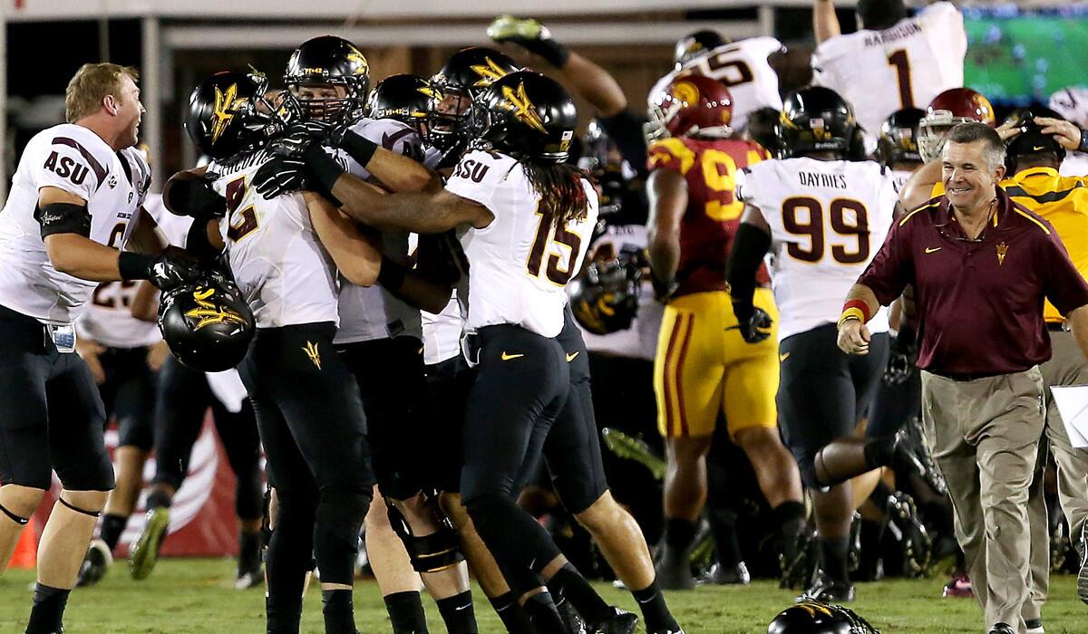 Sun Devils quarterback Mike Bercovici is swarmed by teammates after completing a 46-yard touchdown pass to wide receiver Jaelen Strong on the game's final play to defeat USC on Saturday night at the Coliseum.